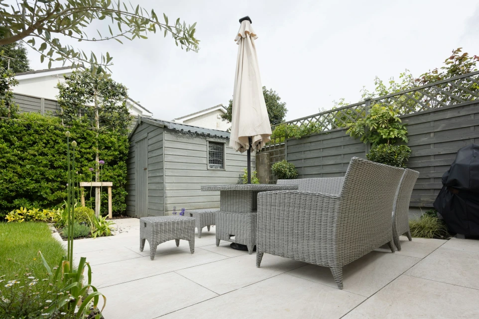 A patio with a table and chairs and an umbrella